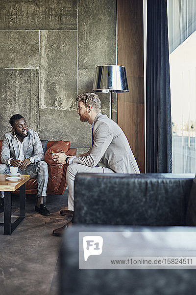 Two businessmen having a coffee break in hotel lobby