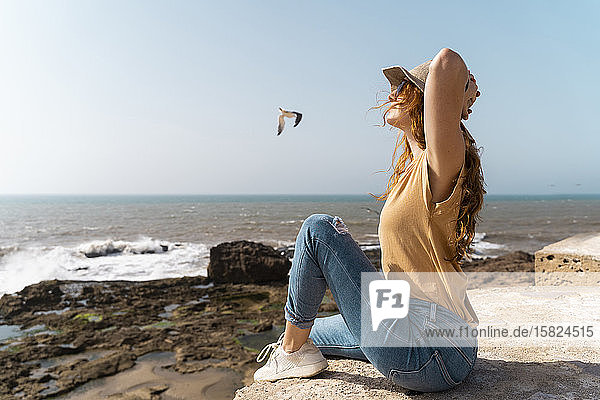 Junge Frau genießt Sonnenlicht in Meeresnähe  Essaouira  Marokko