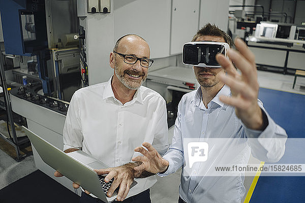 Two men with VR glasses in factory