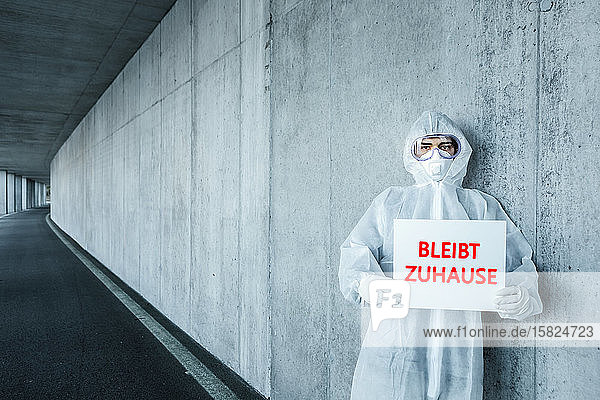 Porträt eines Mannes in Schutzkleidung mit einem Schild