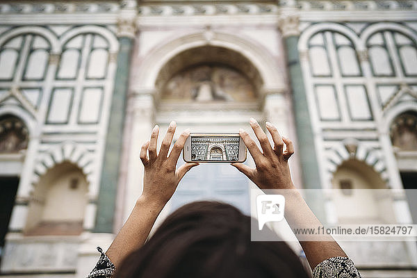 Nahaufnahme einer jungen Frau  die ein Smartphone-Foto in der Stadt macht  Florenz  Italien