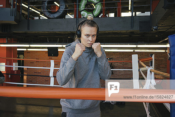 Portrait of a female boxer with headphones in ring