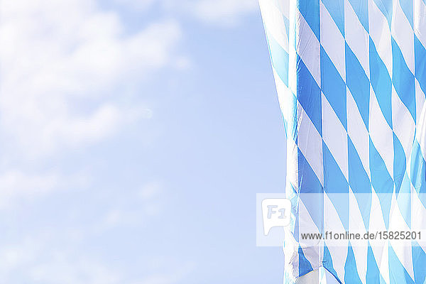 Deutschland  Bayern  München  Niederwinkelansicht der bayerischen Flagge  die während des Oktoberfestes am Himmel hängt