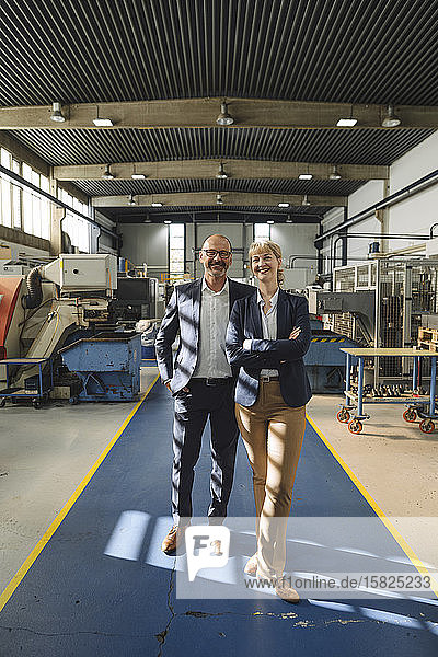 Portrait of confident businessman and businesswoman in a factory