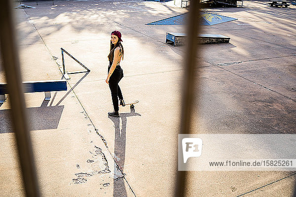 Junge Frau mit Skateboard im Skatepark