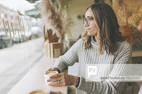 Blonde Frau trinkt Kaffee in einem Café