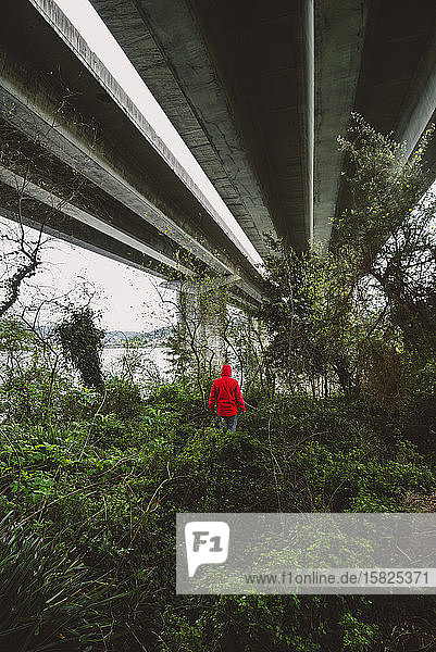Mann unter einer Autobahnbrücke in verlassener Umgebung