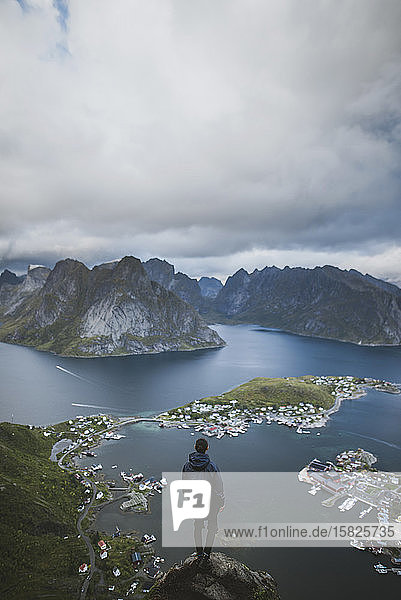 Norwegen  Lofoten  Reine  Mann schaut vom Reinebringen auf den Fjord