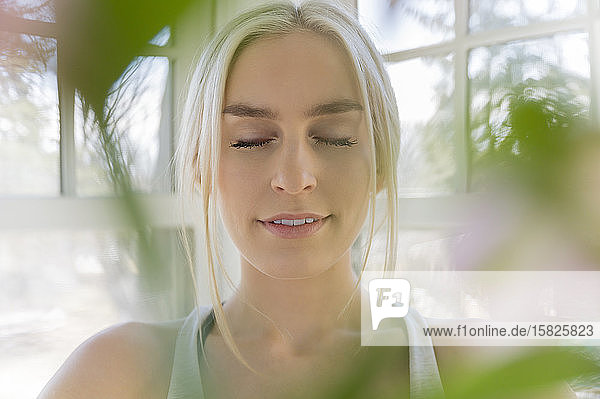 Porträt einer jungen blonden Frau mit geschlossenen Augen