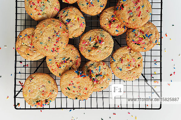 Homemade cookies with colorful sprinkle on baking rackÂ