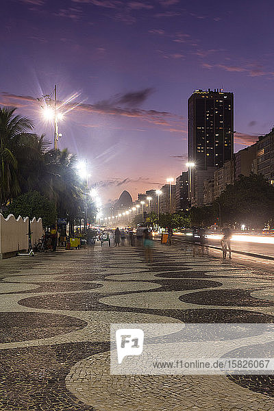 Schöne Aussicht auf den Sonnenuntergang auf den Spaziergang und die Gebäude am Copacabana-Strand