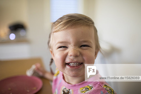Porträt eines süßen Mädchens  das zur Essenszeit lächelt.