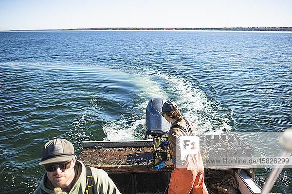 Woman working on conch shellfishing boat on Narragansett Bay