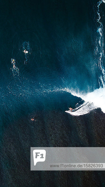 Surfer auf einer Welle über dem Korallenriff