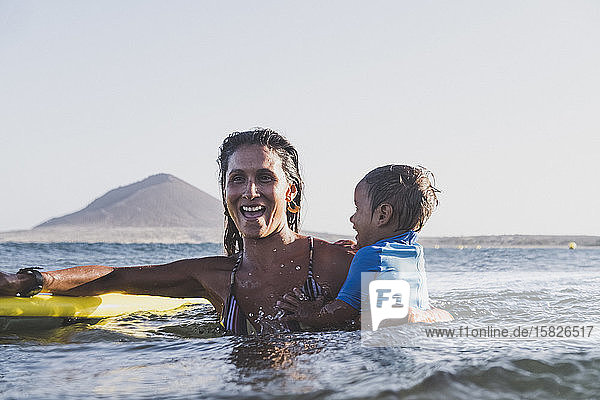Smiley junge Mutter und Sohn spielen auf See