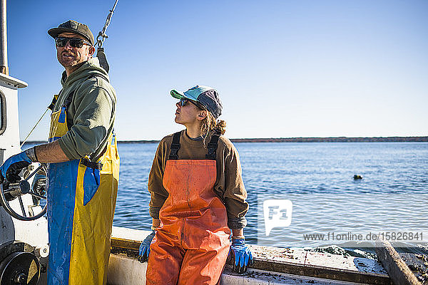 Frau und Mann arbeiten auf einem Muschelboot in der Narragansett Bay