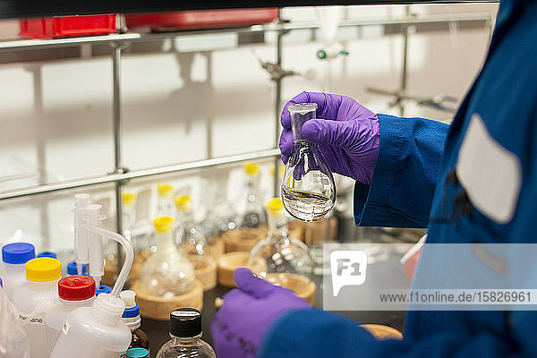 Vorbereiten der Zugabe von klarer Flüssigkeit aus einem Florenz-Kolben in einem Labor