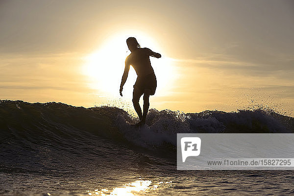 Silhouette of surfer at sunset