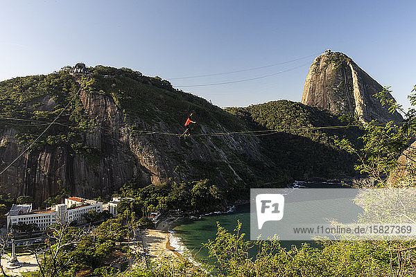 Slackliner walking on highline with Sugar Loaf Mountain on the back