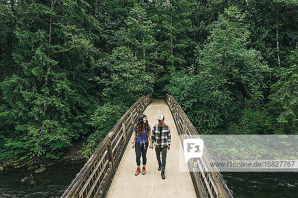 Ein junges Paar genießt eine Wanderung auf einer Brücke im pazifischen Nordwesten.
