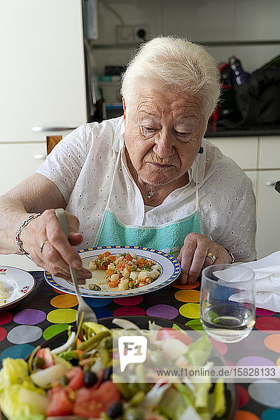 Alte Dame  die allein isst und sich zu Hause gesund ernährt
