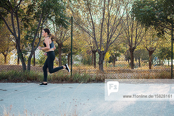 Young woman is running in a city park. Female athlete  sport concept.