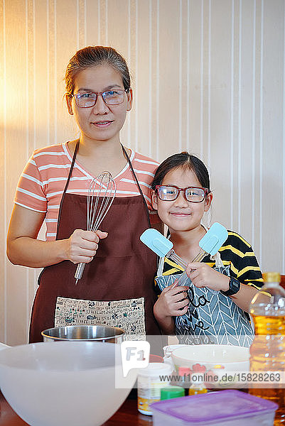 Portrait of mother and daughter in kitchen