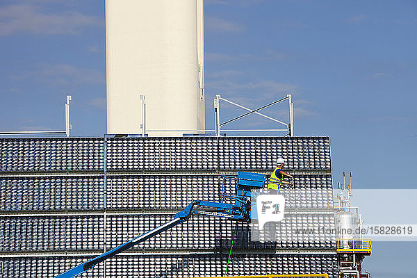 Ein Mann reinigt hochkonzentrierte Photovoltaik-Paneele  die von der Forschungs- und Entwicklungsabteilung von Abengoa Solar in deren Solucar-Solarkomplex in Sanlucar la Mayor  Spanien  getestet werden. Abengoa a