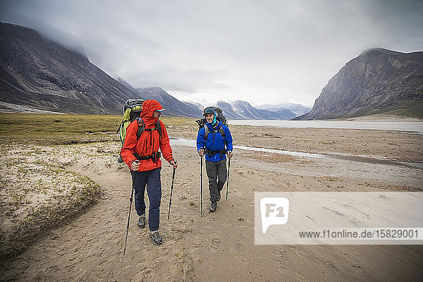 Front view of backpackers hiking in the rain  Baffin Island  Canada.
