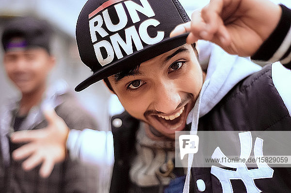 Young playful guy wearing hip hop cap and sports clothing