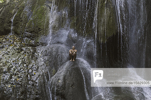 Mann klettert auf Wasserfall