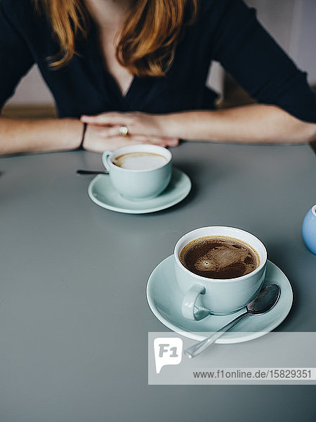 Eine Frau und zwei Tassen Kaffee im Café