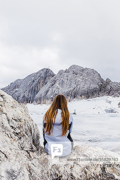 junges tausendjähriges Mädchen geniesst die Aussicht auf die Alpen auf einem Gletscher