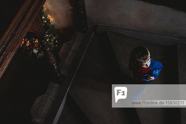 Ein kleiner Junge geht eine dunkle Treppe hinunter.