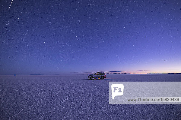 vehicle on salar de uyuni at sunset