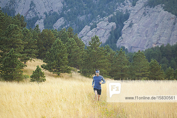 Mann rennt durch hohes Gras auf dem Bear Canyon Trail in Boulder  Colorado