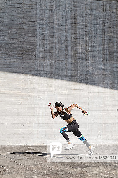 Female athlete running on concrete vertical