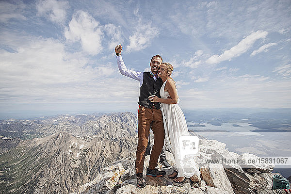 Neuvermähltes Brautpaar feiert nach der Heirat auf dem Berg