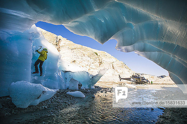 Mann klettert während einer Abenteuer-Hubschraubertour auf Gletschereis