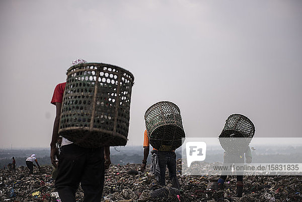 Müllsammler gehen auf der Deponie auf der Suche nach Materialien zum Recycling