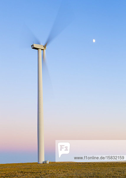 Windturbine in Bewegung gegen blauen Himmel mit Mond