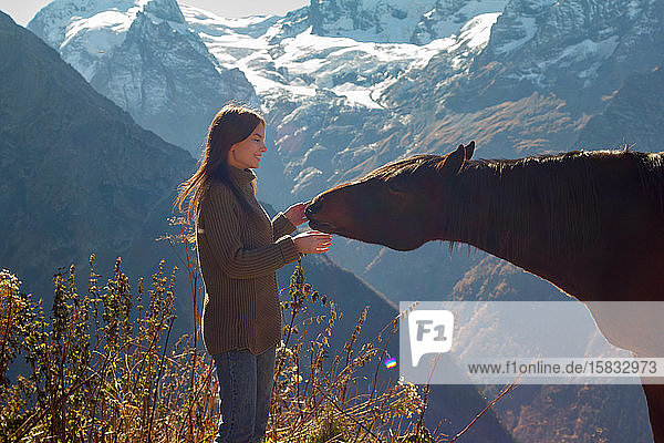 Mädchen mit einem Pferd im Hintergrund der Berge