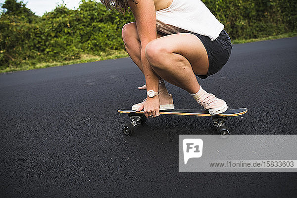 Junge Frau beim Skateboarden im Sommer