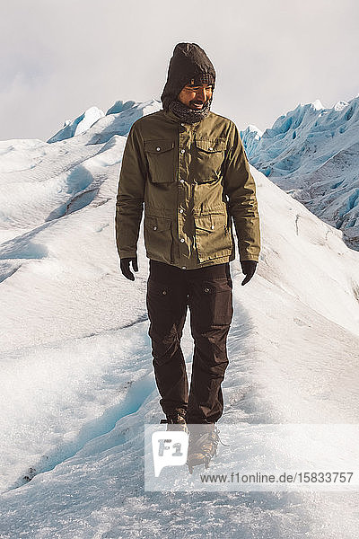 Male explorer smiling and walking on glacier