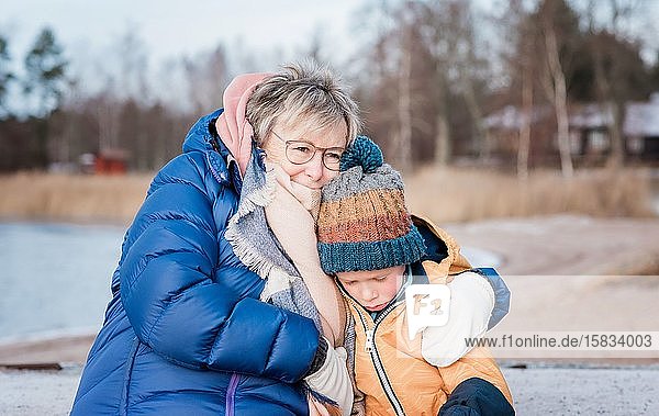 Großmutter tröstet ihren Enkel  während sie im Winter draußen spielt