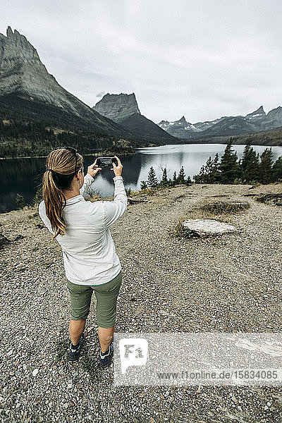 Frau fotografiert mit dem Handy die Aussicht auf die Berge  Montana