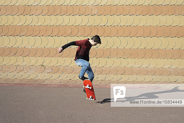 Junge Junge skatet auf Rampe in einem Stadtpark an einem sonnigen Tag