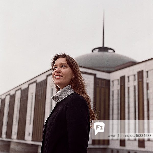 Eine Frau steht neben einem schönen Gebäude