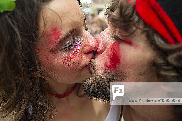 Junges Paar küsst sich leidenschaftlich auf dem Karneval