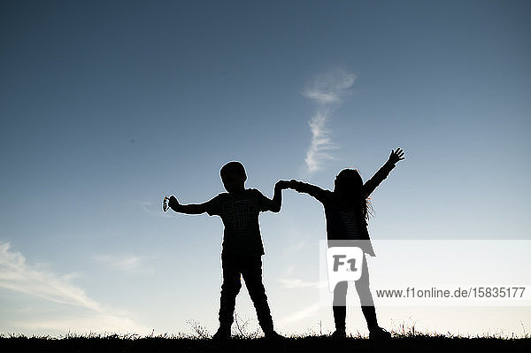 Silhouettierte Kinder spielen auf einem Hügel in Waco  Texas